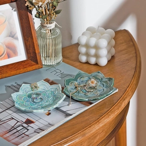Detailed view of lotus ceramic jewelry trays in blue and green on a wooden table