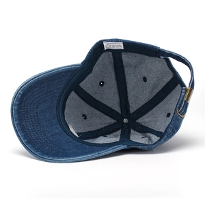 Detail view of denim baseball cap with 100% cotton wash label and metal buckle adjustment