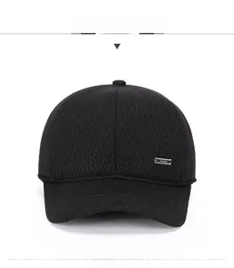 Detail of black knit baseball cap with silver Fashion logo plate and textured fabric