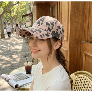 Outdoor model wearing a pink leopard print baseball cap with a classic curved brim