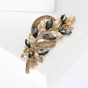 Close-up of golden wheat brooch with champagne and grey marquise crystal accents