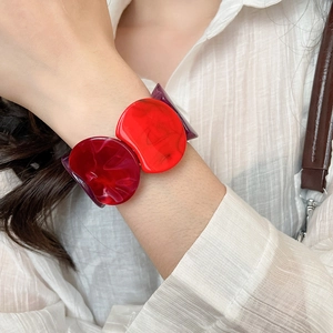 Close-up of stylish chunky acrylic link bracelet with vibrant red and burgundy marble effect