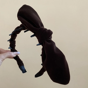 Detailed close-up of dark brown velvet knotted headband with non-slip inner teeth design