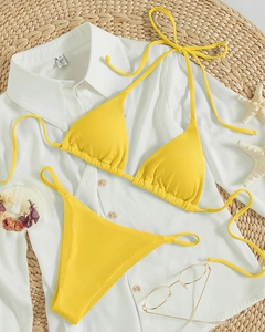 Close-up of bright yellow ribbed fabric texture on halter string bikini set
