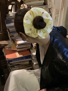 Dettaglio di elastico per capelli giallo con fiori ricamati sui capelli della modella
