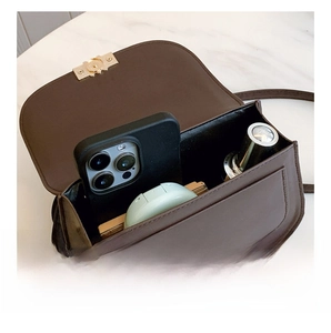 Interior view of brown retro crossbody bag showing capacity for phone and cosmetics