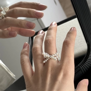 Detailed close-up of a s925 silver ring featuring a beaded pearl bow on a hand