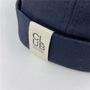 Detailed close-up of navy docker hat featuring premium twill cotton fabric and side label