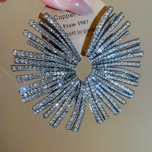 Macro shot of geometric fan earrings with sparkling crystals and a radiant starburst design