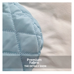 Macro shot of light blue quilted nylon fabric texture with classic diamond stitching pattern