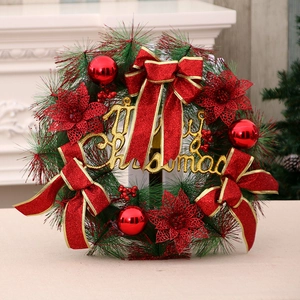 Artificial Christmas wreath with red poinsettia flowers and golden Merry Christmas sign