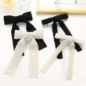 Detail of handmade beaded bow hair clip with pearl texture and geometric pattern