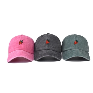 Three washed cotton baseball caps in pink, charcoal, and dark green with strawberry embroidery