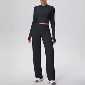 Détail de l'ensemble de sport noir avec manches passe-pouce et pantalon à jambes larges