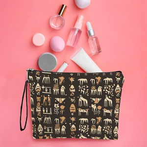 Brown canvas makeup bag with tribal patterns and wristlet on a pink background