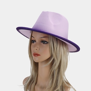 Detail view of a two-tone purple wool fedora hat with a wide brim on a display head
