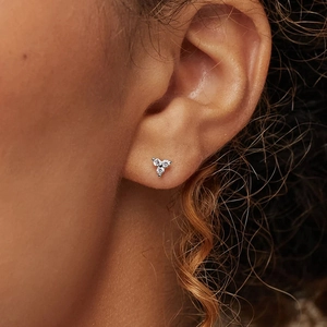 Élégantes boucles d'oreilles argentées avec trois petits diamants ronds en forme de triangle