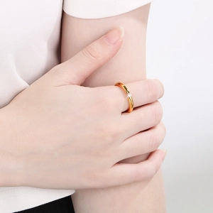 Detail of 18k gold plated ring with a sparkling zircon stone worn on a finger