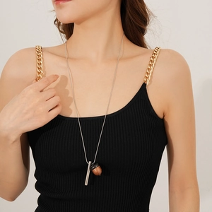Silver long necklace with wooden acorn pendant worn by model in black camisole