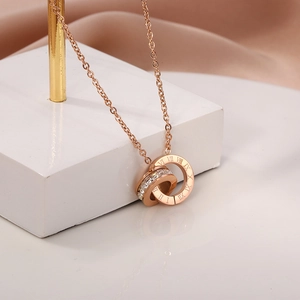 Detail of rose gold interlocking circles pendant with Roman numerals and crystals