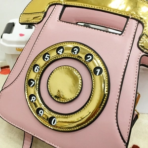 Close-up of pink vintage rotary phone crossbody bag with gold metallic sequins and PU leather