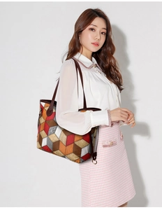 Detail of colorful geometric patchwork tote bag with 3D cube texture on shoulder