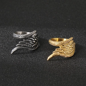 Detailed engraving of feather textures on silver and gold wing wrap rings for men