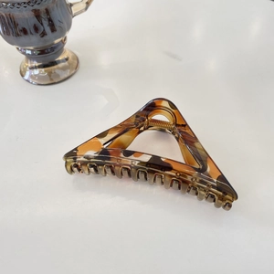 Close-up of a triangular tortoise shell hair claw clip with glossy gradient texture