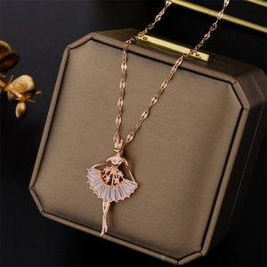 Rose gold ballet dancer necklace with clear crystal pendant on a brown jewelry box