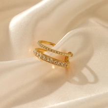 Makro-Detail eines doppellagigen Goldrings mit quadratischen und runden Kristallen