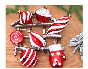 Detail of red and white Christmas ornaments including candy canes and gloves on pine branches