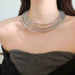 Detail of silver triple-layered spring choker with textured metallic horizontal stripes