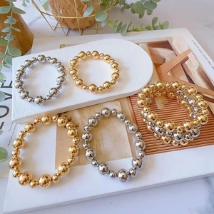 Chic 6mm and 10mm gold and silver beaded stretch bracelets in a stylish layered display