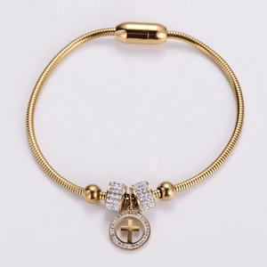 Detail of gold snake chain bracelet with magnetic clasp and crystal cross pendant