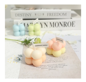 Detail of colorful cube-shaped handmade candles with minimalist labels and books