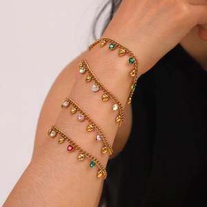 Bracelet à chaîne cubaine dorée avec pierres précieuses en forme de cœur sur un mannequin