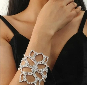 Detail view of silver hollow flower bracelet with sparkling rhinestones on female wrist