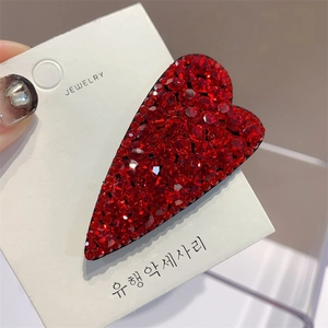 Detail of red heart hair clip with crystals on a white jewelry display card
