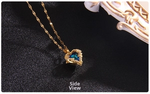 Side view of heart-shaped dark blue crystal necklace with sparkling wings and gold chain