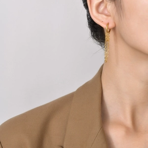 Detail shot of a model wearing golden stainless steel chain drop earrings with circles
