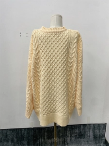 Gros plan sur la maille torsadée jaune pâle de ce pull ample décontracté à manches longues