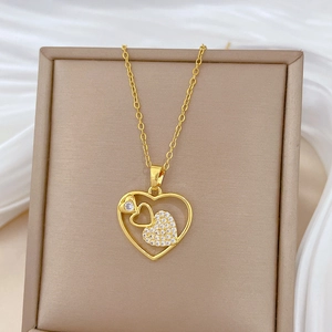 Luxurious gold hollow heart pendant necklace with rhinestones on white satin backdrop