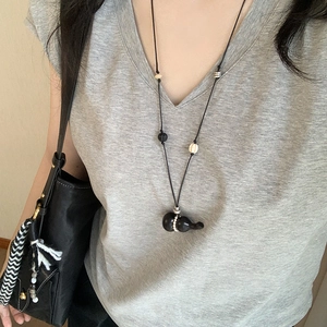 Vintage wax rope necklace with wooden gourd pendant and pearl beads on a model