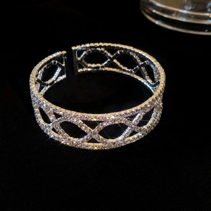 Macro-opname van de zilveren gekruiste open armband met sprankelende zirkonia-stenen