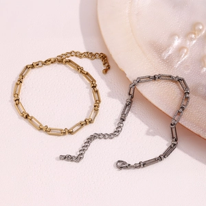 Detail of 14K gold and silver paperclip link bracelets with lobster clasp and pearl accent