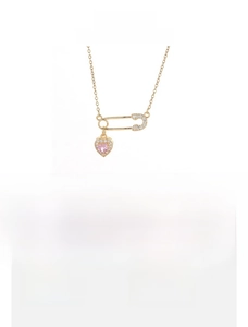 Detailed close-up of a titanium steel safety pin necklace with pink heart zircon pendant