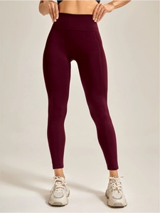 Detail der nahtlosen High-Waist-Yogahose in Burgunderrot mit geripptem Bauchkontrollbund