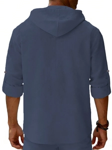 Detail of blue linen hooded shirt back showing adjustable rolled sleeves and hood texture