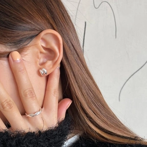 Detail of minimalist S925 sterling silver curved earrings and rope ring on model