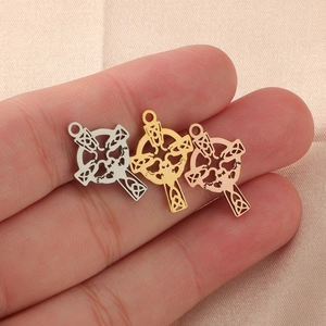 Three Celtic knot cross pendants in silver gold and rose gold finish held on fingers